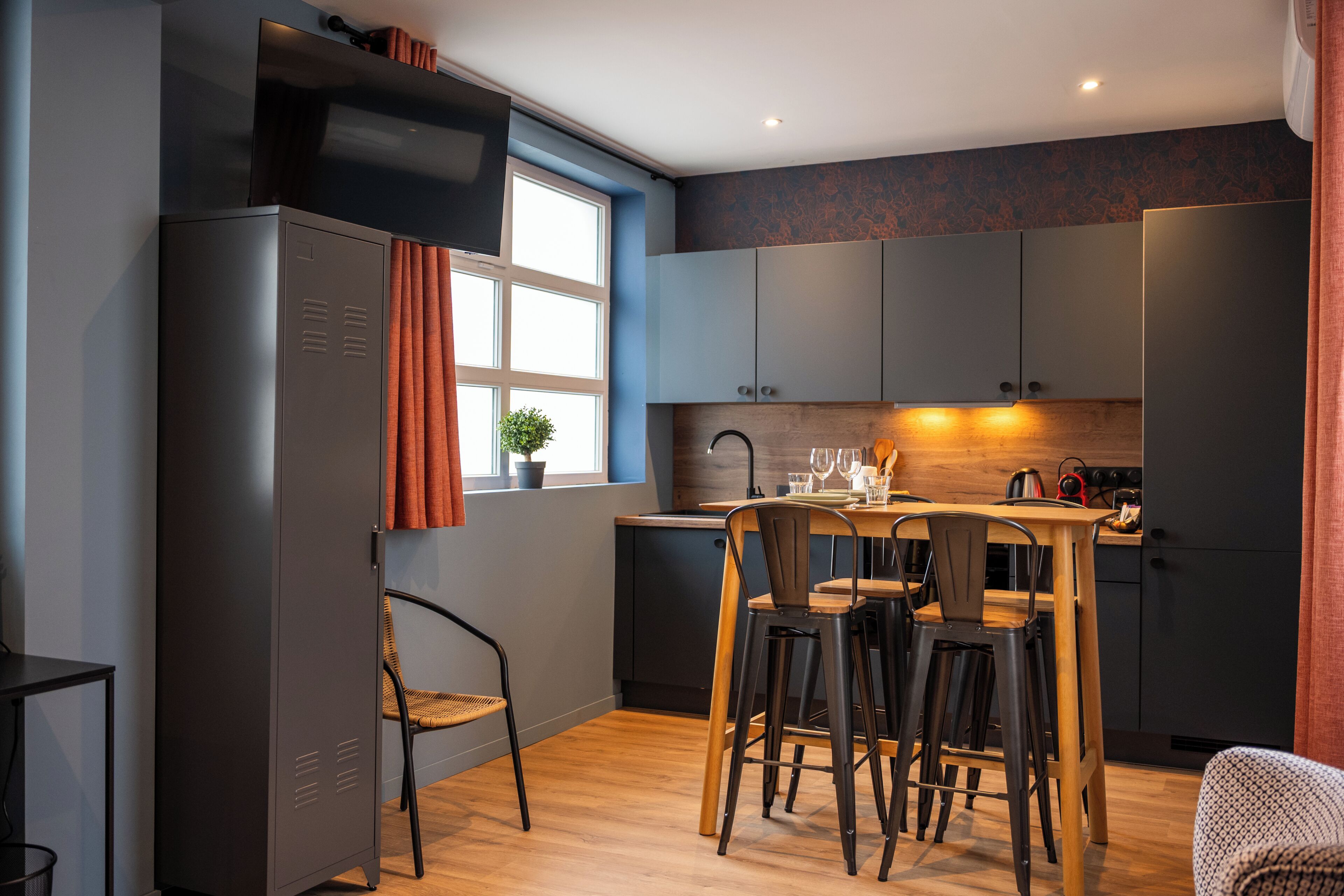 A modern kitchen with a dining table, chairs, and a small island.
