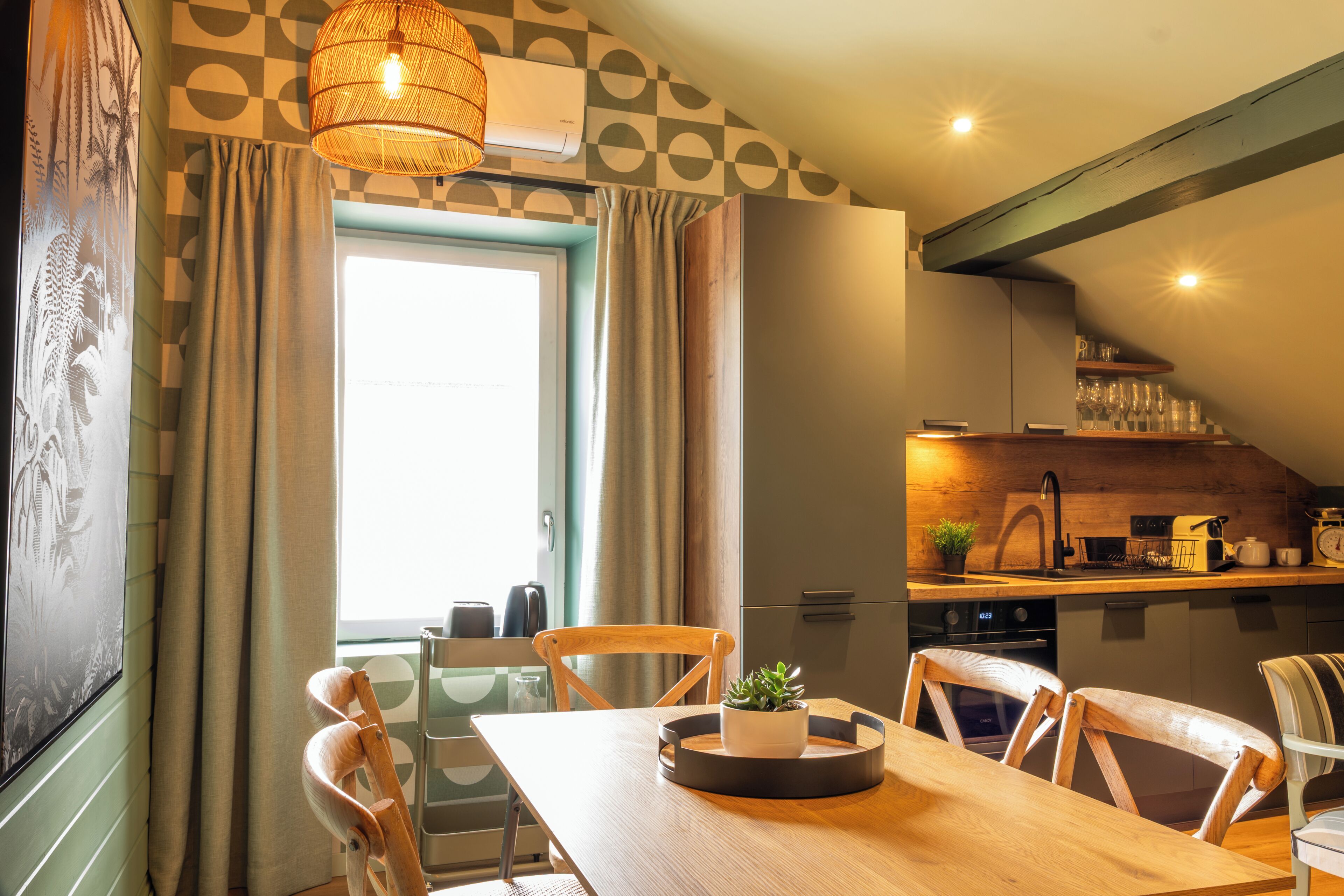 A dining area with a wooden table, chairs, and a potted plant.