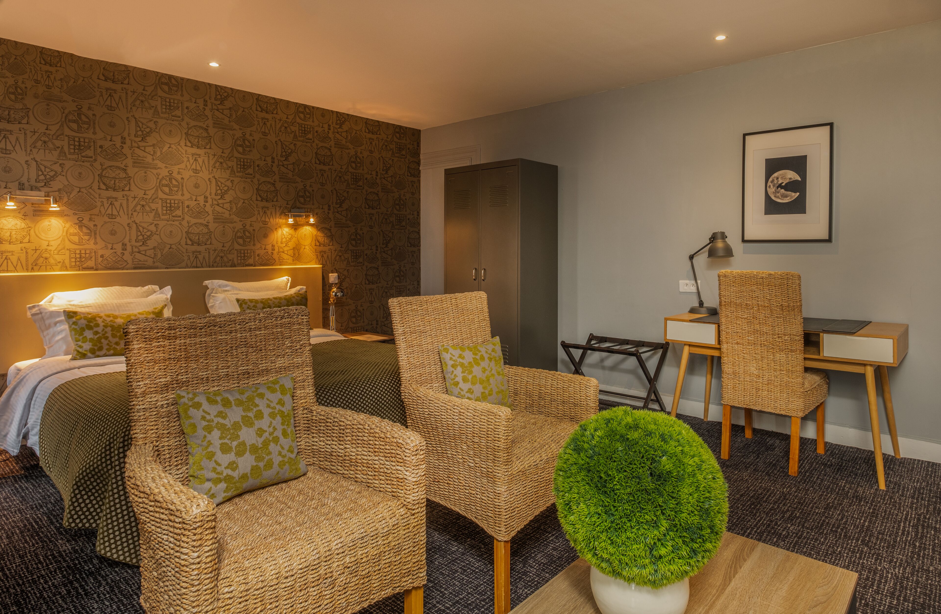 A modern hotel room with wicker furniture, a desk, and a large mirror.