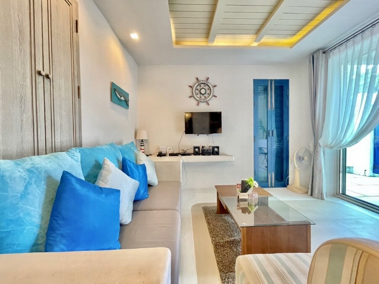 Ein modernes Wohnzimmer mit einer Couch, einem Couchtisch und einem flachbildfernseher an der Wand.
