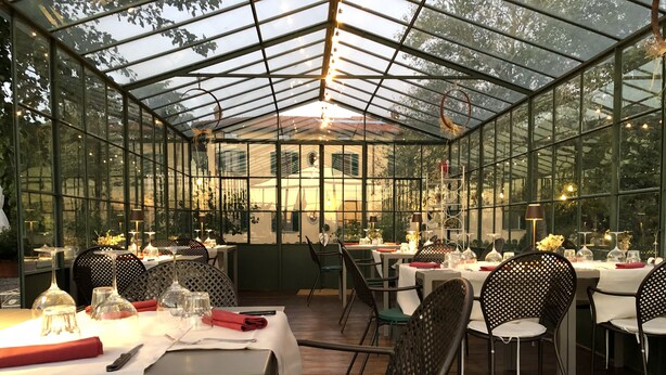 A restaurant with glass walls, tables set with white tablecloths, and chairs. - La Cantina Relais - Fattoria Il Cipresso (Arezzo)