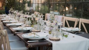A long dining table set with plates, glasses, and floral centerpieces, surrounded by chairs. - La Cantina Relais - Fattoria Il Cipresso (Arezzo)