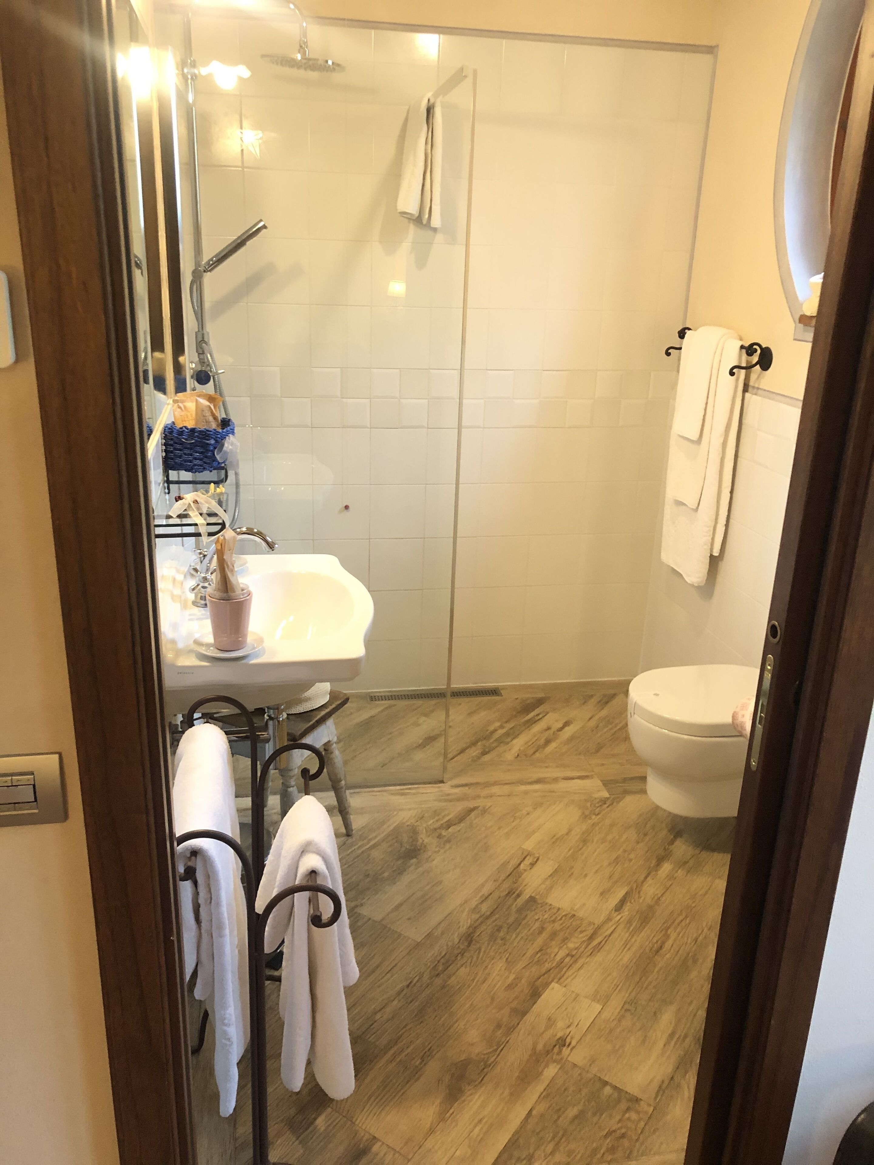 A bathroom with a glass shower enclosure, a white sink, and a toilet.