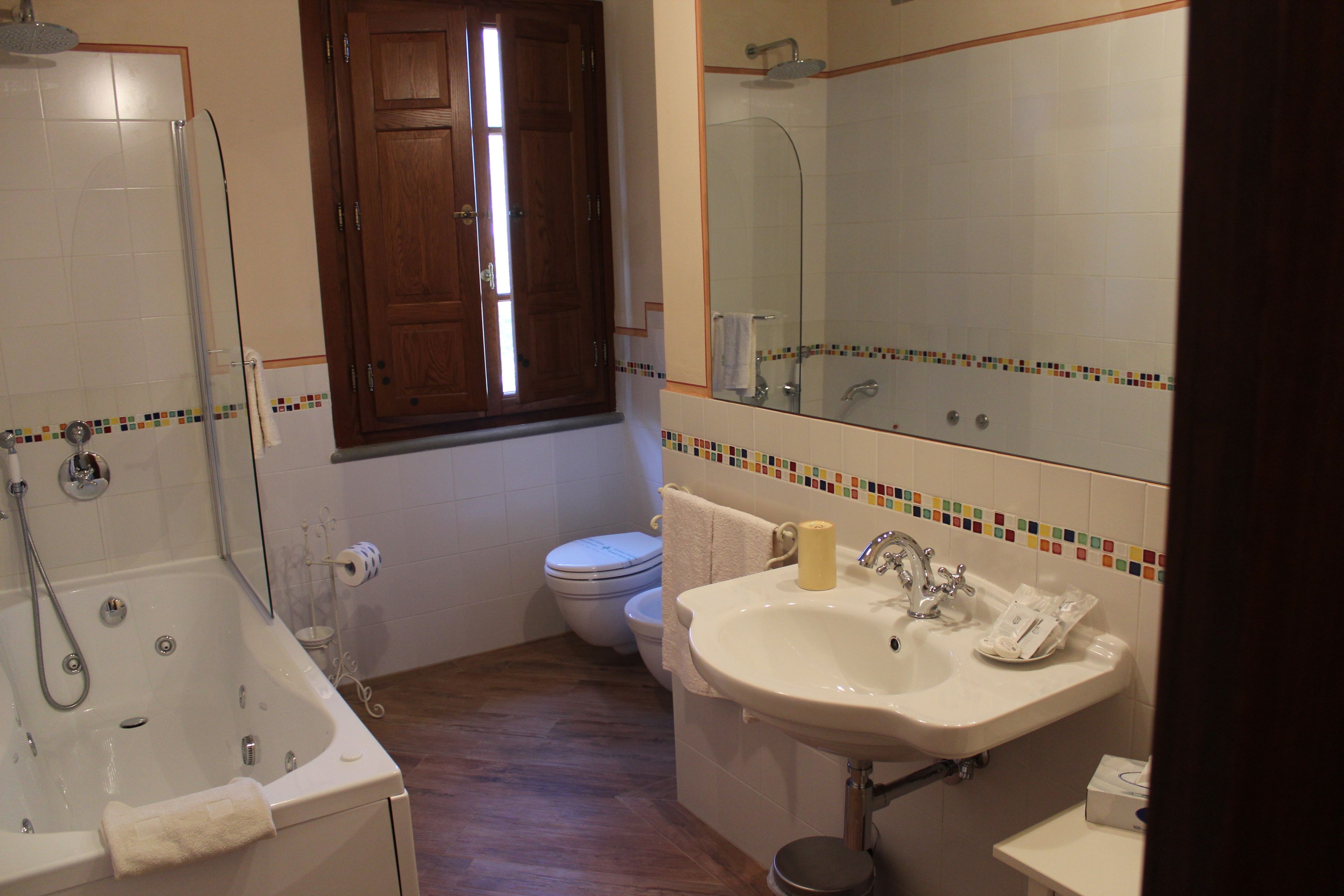 Un baño con bañera, inodoro y lavamanos.