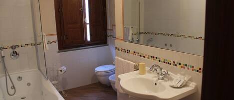 Un baño con bañera, inodoro y lavamanos.