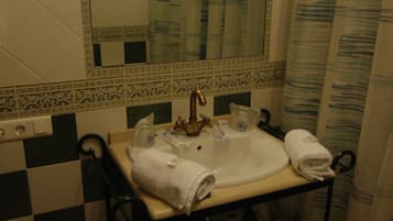 A bathroom with a checkered floor, a sink with a towel, and a mirror.