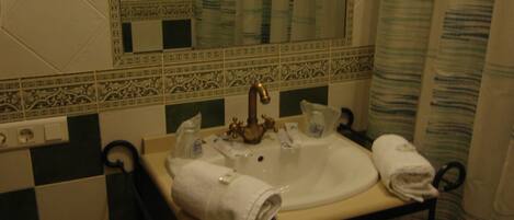 A bathroom with a checkered floor, a sink with a towel, and a mirror.