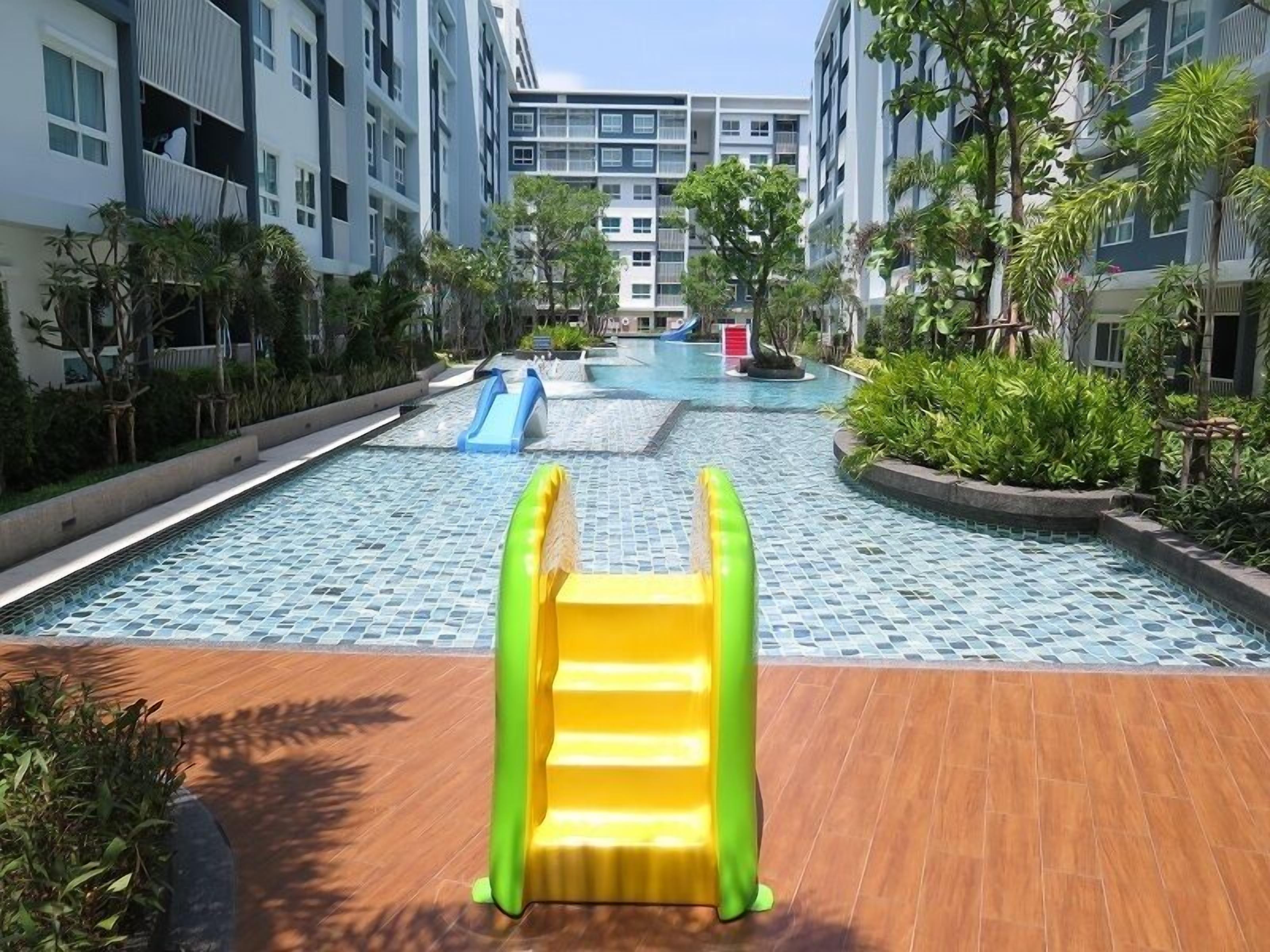 A swimming pool area with a slide and inflatable play structures.