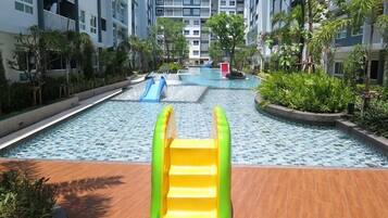 A swimming pool area with a slide and inflatable play structures.