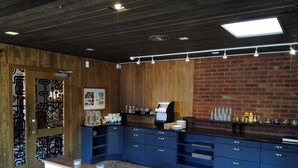 Une cuisine moderne dotée d’un coin café, de lambris en bois et d’un mur en briques.