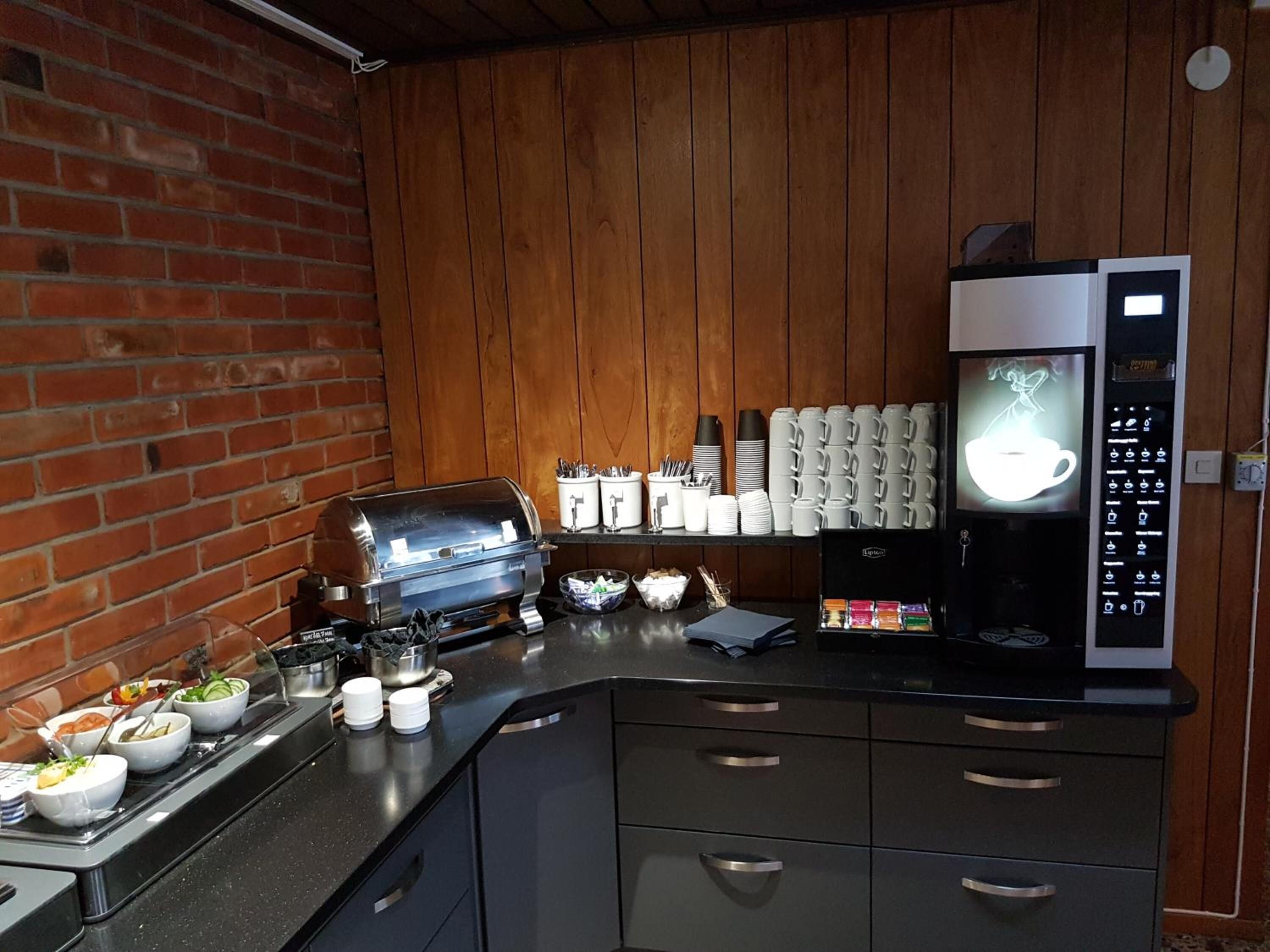 Una zona de cocina con cafetera, tostadora y varios recipientes de alimentos en la encimera.