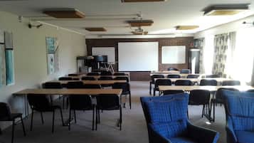 A classroom with desks and chairs, a whiteboard, a projector, and a screen.