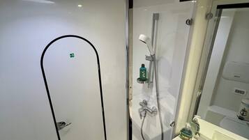 A modern bathroom with a shower, sink, and mirror.