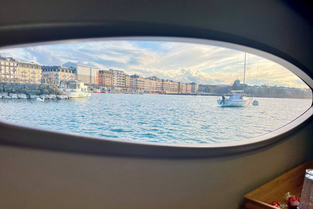 Blick aus einem Fenster auf einen Hafen mit Booten und Gebäuden.