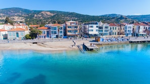 A coastal town with a marina, buildings with balconies, and a clear view of the sea. - Foca Kumsal Hotel (Foça)