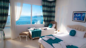 A hotel room with two beds, a view of the sea, and a painting on the wall. - Foca Kumsal Hotel (Foça)