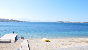 A beach with a wooden pier and a yellow boat. - Foca Kumsal Hotel (Foça)