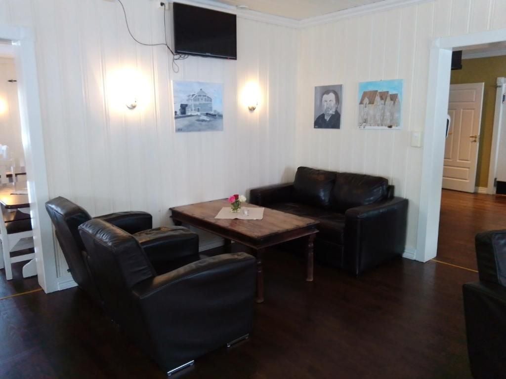 A living room with a sofa, a coffee table, and a television mounted on the wall.