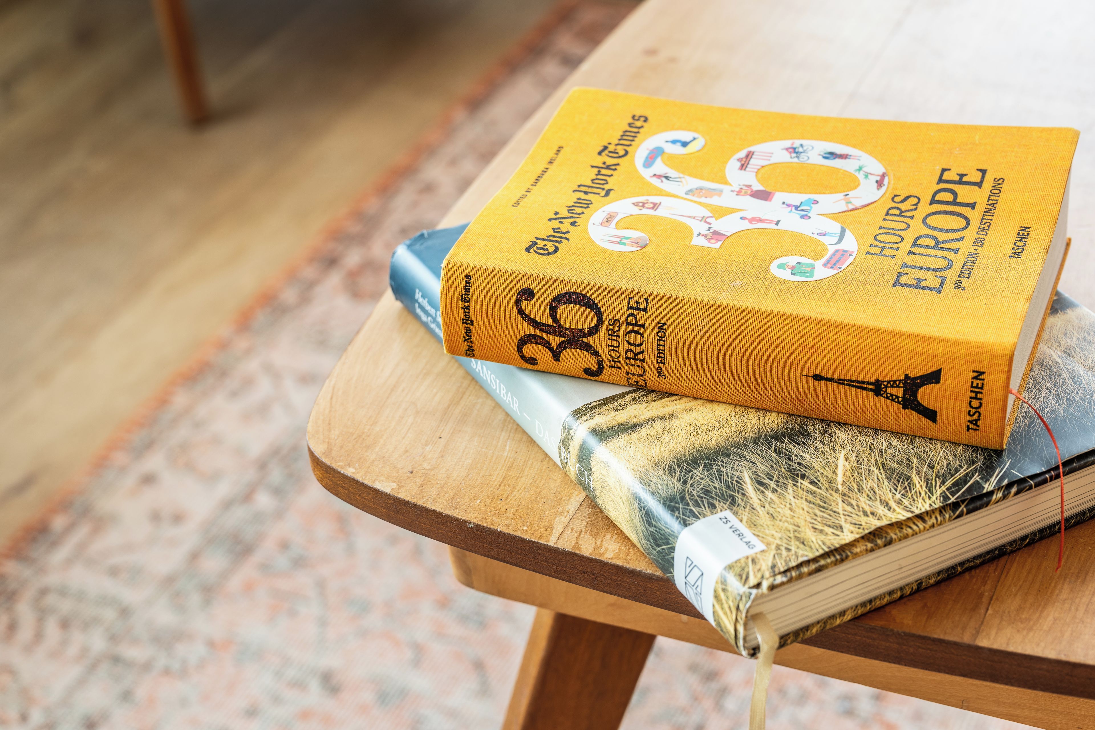 A stack of books on a wooden table.