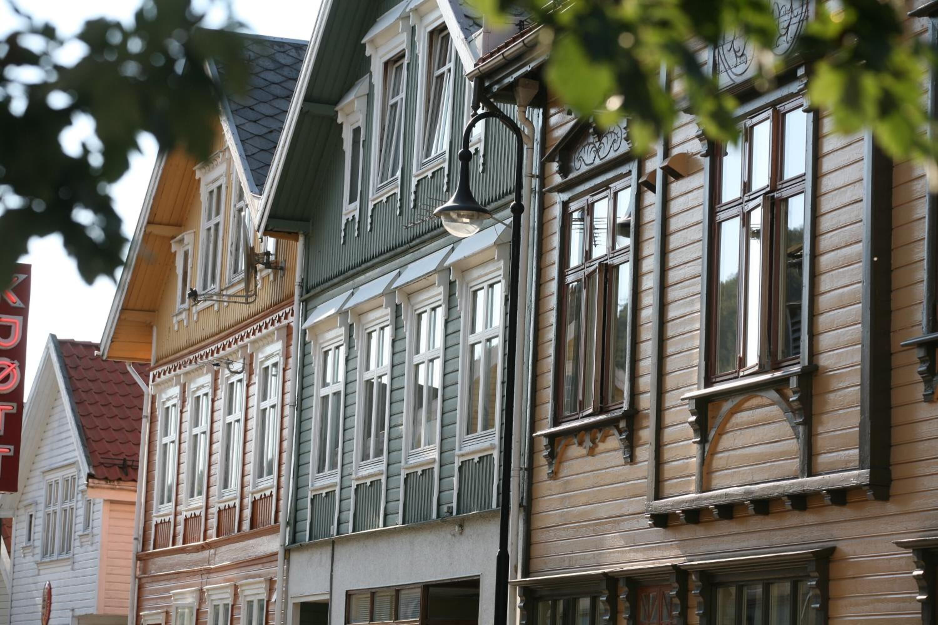 Una hilera de edificios tradicionales de estilo europeo con características arquitectónicas notables, como marcos de ventanas ornamentados y diversos tipos de tejados.