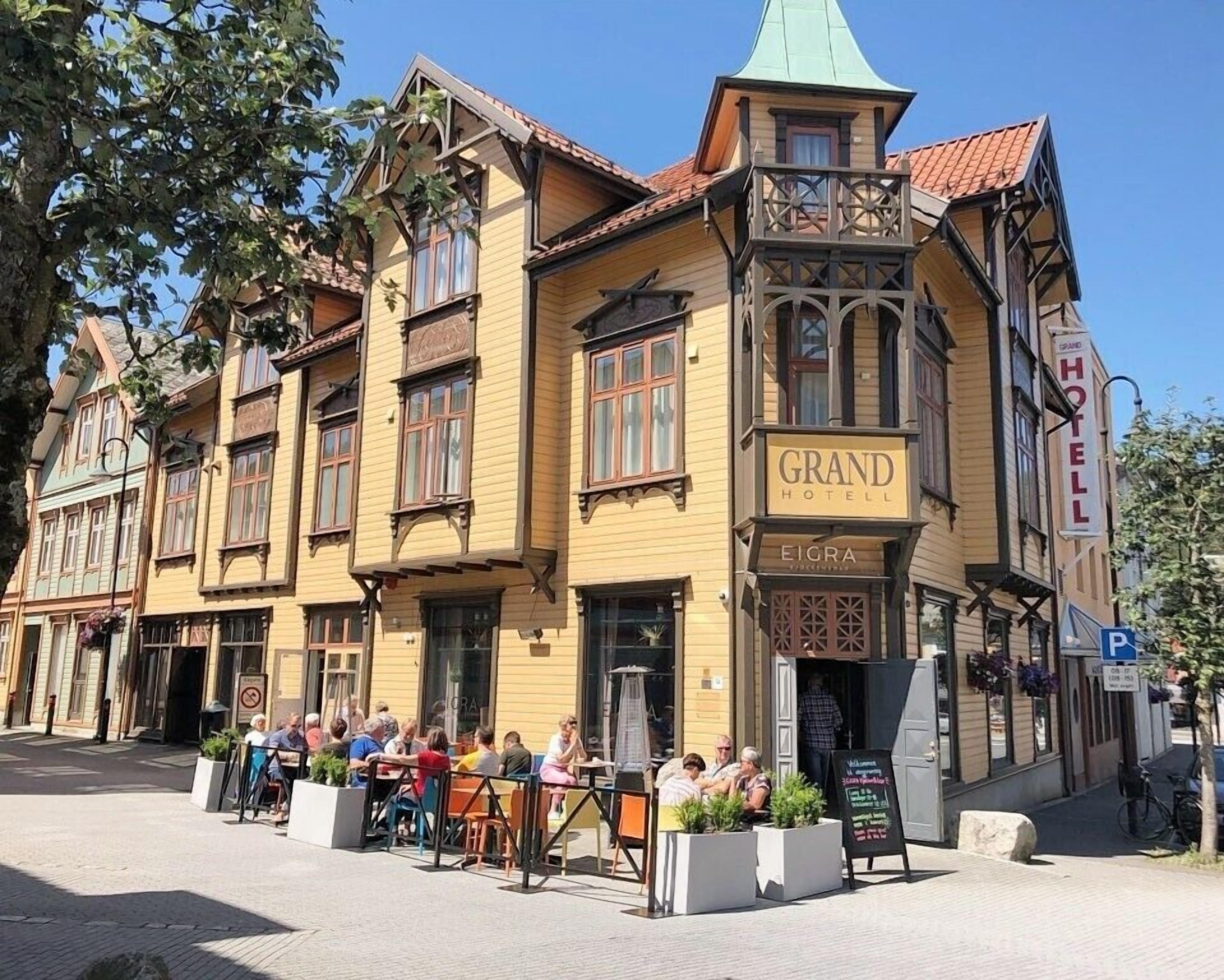 Un bâtiment historique sur lequel on peut lire l’inscription « GRAND HÔTEL », et qui possède un balcon surmonté d’un toit végétalisé.