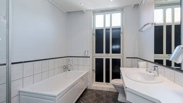 A modern bathroom with a bathtub, toilet, and sink.