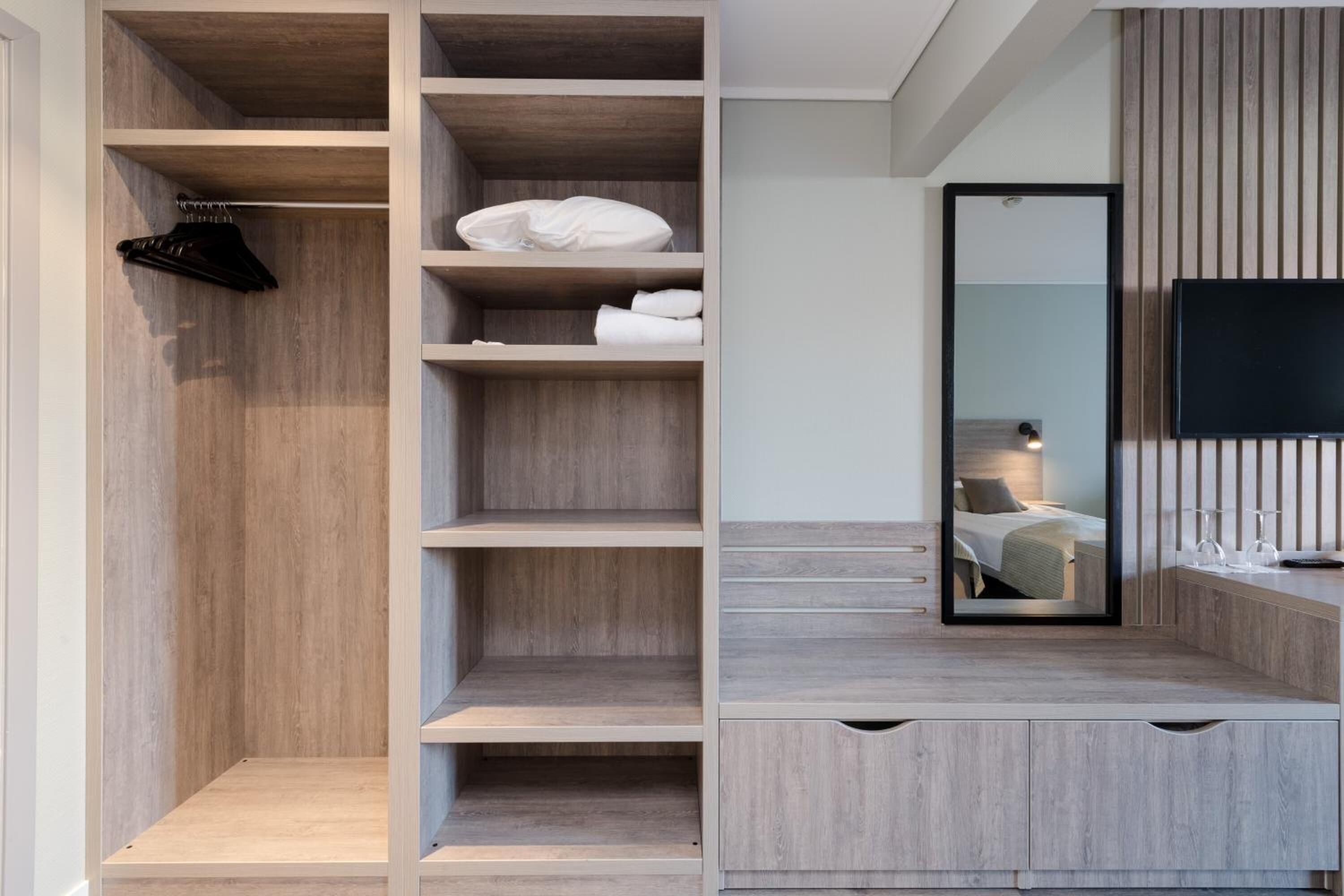 A modern bathroom with a wooden vanity, a mirror, and a built-in shower area.