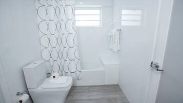 Un baño moderno con inodoro, ducha y bañera.