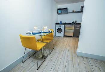 A modern bathroom with a glass-enclosed shower, a toilet, and a sink. at Seaside All Suites Hotel