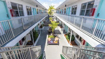 Un hotel de varios pisos con un patio central que ofrece asientos al aire libre y plantas.