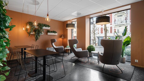 Et moderne interiør med spiseplads, siddepladser og planter.