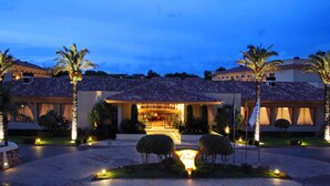 A hotel with multiple buildings, palm trees, and well-lit pathways. - La Quinta Menorca by Portblue Boutique (Ciutadella de Menorca)