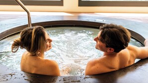 A couple in a hot tub with a view of greenery through windows. - La Quinta Menorca by Portblue Boutique (Ciutadella de Menorca)
