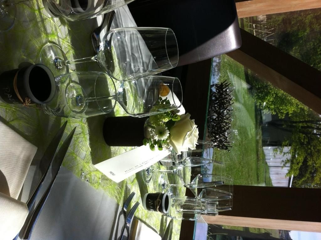Una mesa de comedor dispuesta con copas de vino, un vaso de agua y cubiertos.