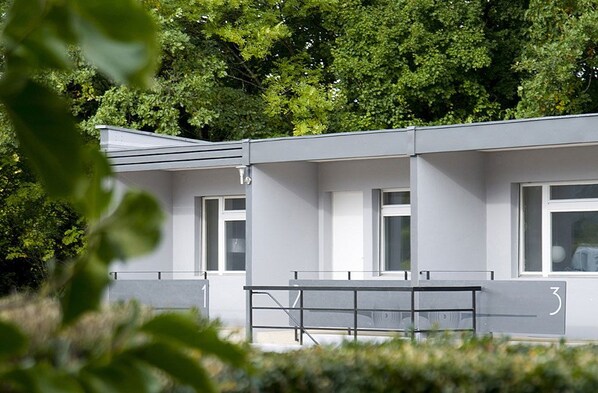 A modern building with a flat roof, large windows, and a number '3' on the side. - Relais de l'Aérodrome (Prangins)