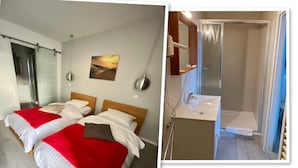 Hotelkamer met twee bedden, een badkamer met douche, een televisie en een inloopkast.