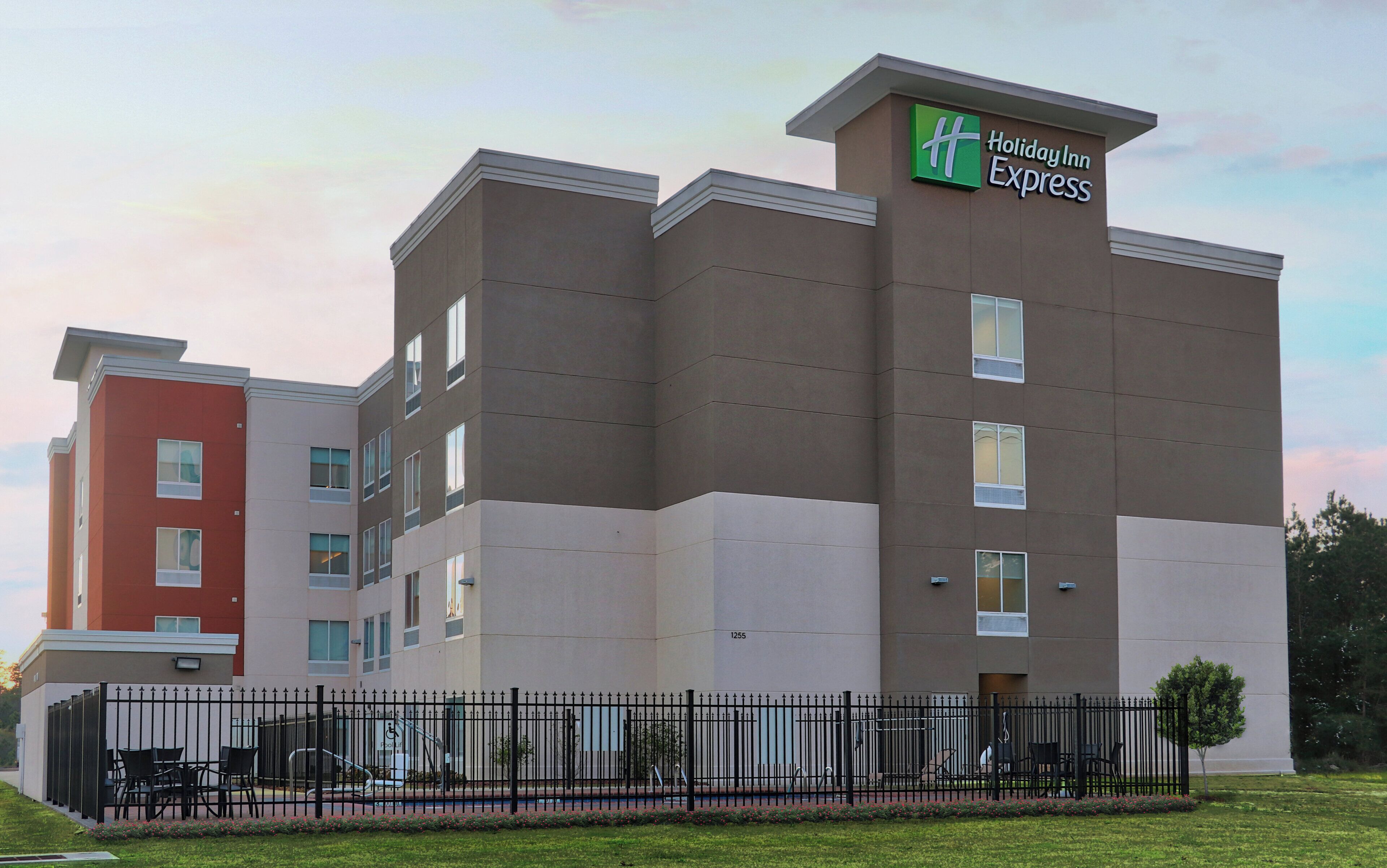A multi-story Holiday Inn Express hotel with a modern design, featuring a prominent green and white logo.