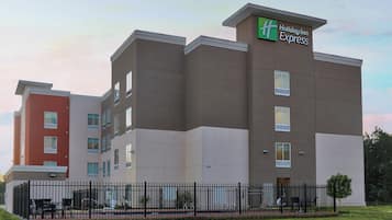 A multi-story Holiday Inn Express hotel with a modern design, featuring a prominent green and white logo.