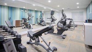 A fitness center with various exercise equipment, including treadmills, stationary bikes, and weight machines.