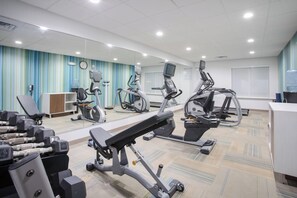 A fitness center with various exercise equipment, including treadmills, stationary bikes, and weight machines.