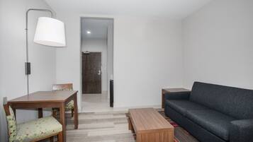 Una sala de estar moderna con una mesa de comedor de madera, un sofá y una lámpara.