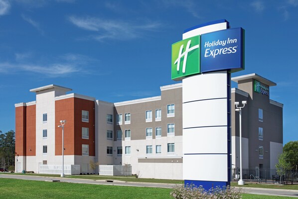 A Holiday Inn Express hotel with a modern design, featuring a mix of brick and stucco exteriors, multiple windows, and a prominent signage.