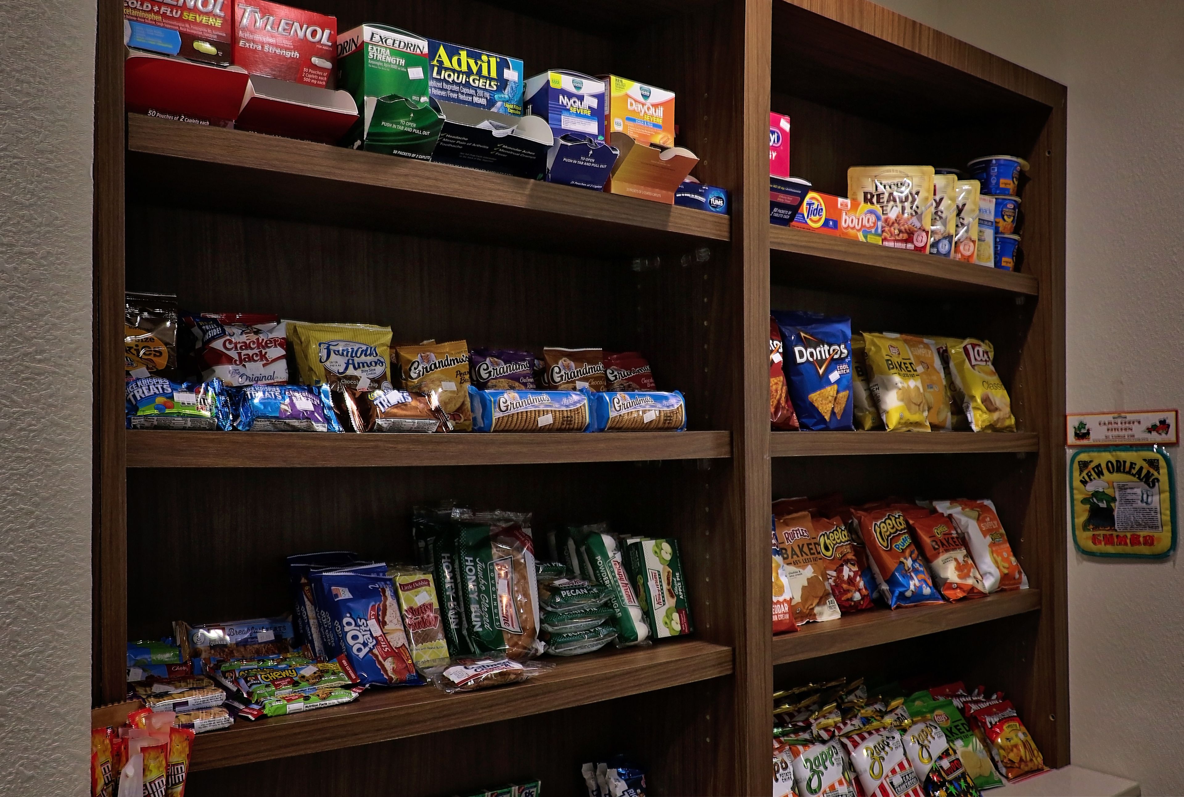 A pantry with various food items including snacks, cereals, and beverages.