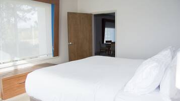 Un dormitorio con una cama grande, cabecera de madera y una ventana con persianas.