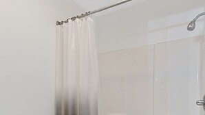 Une salle de bain équipée de toilettes, d’une baignoire et d’une douche.