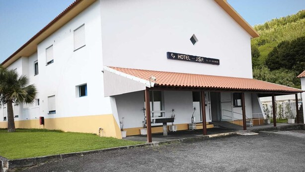 A two-story building with a sign indicating it is a hotel.