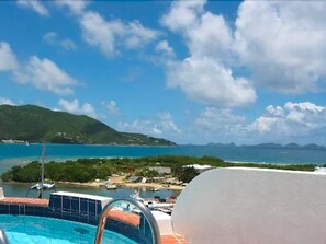 A swimming pool with a view of a coastal area, including a body of water and distant mountains. - Fort Burt Hotel (Road Town)