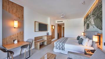 A modern hotel room with a bed, desk, and seating area.
