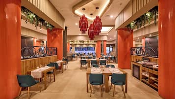A spacious restaurant with high ceilings, red accents, and modern decor.