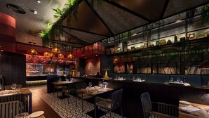 A restaurant with a bar area, seating, and a patterned floor. - Hotel Riu Palace Mauritius - All Inclusive - Adults Only (Le Morne)